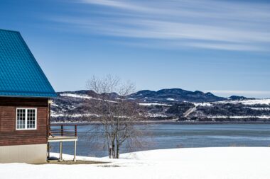 A wooden cabin in northern Quebec on the snowy shore